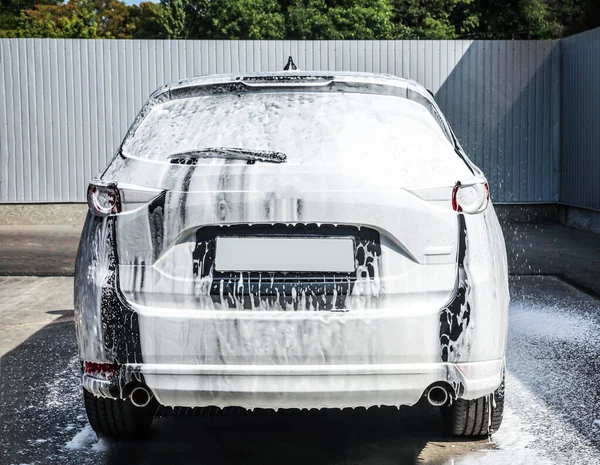 Araba yıkamada köpükle kaplı lüks bir otomobil. — Stok fotoğraf