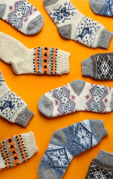 Chaussettes tricotées différentes sur fond orange, à plat. Vêtements d'hiver — Photo