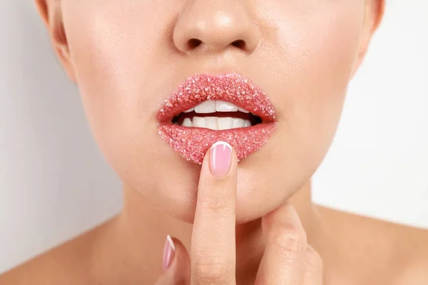 Mujer joven con labios de azúcar sobre fondo blanco, primer plano — Foto de Stock