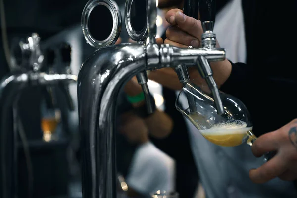 Bartender pouring beer into glass in pub, closeup — Stock Photo, Image