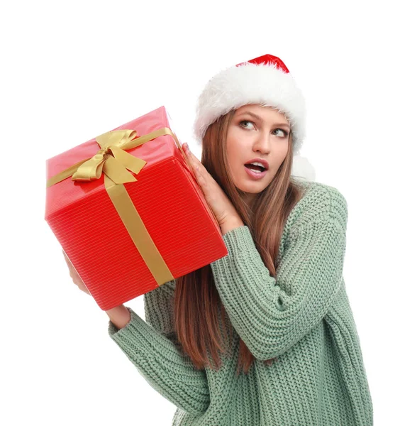 Jovem mulher emocional em chapéu de Santa com presente de Natal no fundo branco — Fotografia de Stock