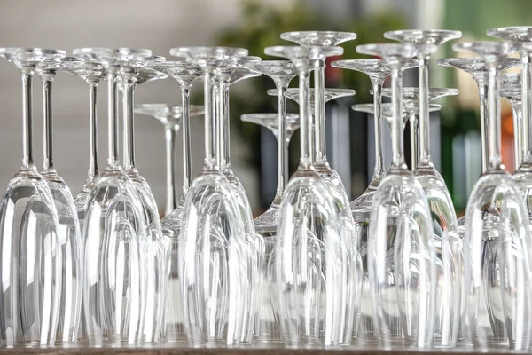 Empty glasses on wooden table against blurred background — Stock Photo, Image