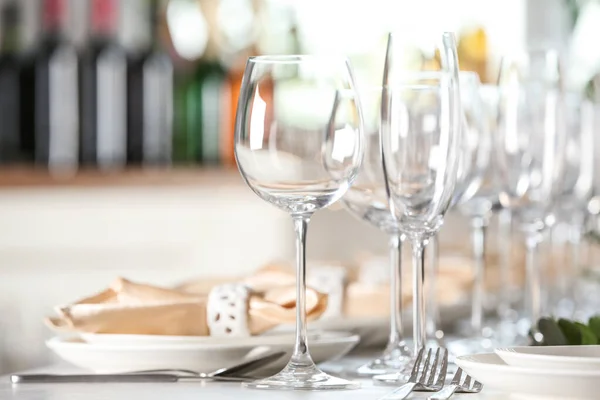 Ajuste de mesa con vasos, platos y cubiertos vacíos en interiores — Foto de Stock