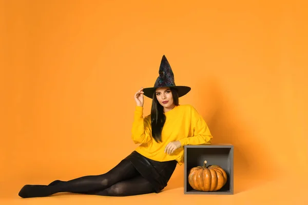Gyönyörű nő visel boszorkány jelmez Halloween party sárga háttér — Stock Fotó