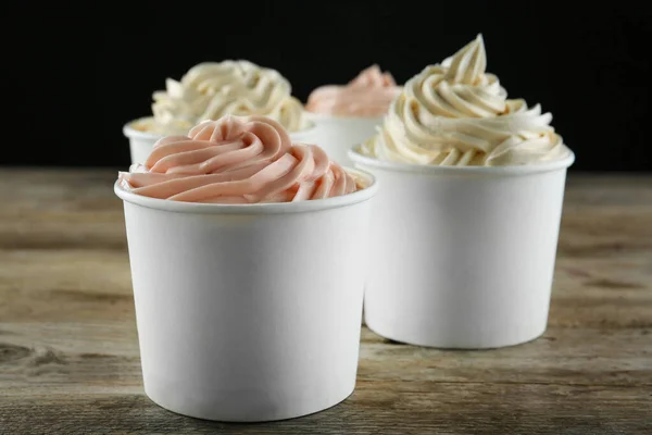 Copas con sabroso yogur helado sobre mesa de madera — Foto de Stock