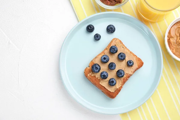 Na bílém stole leželo ploché složení toastu s arašídovým máslem a borůvkami. Zdravá snídaně — Stock fotografie