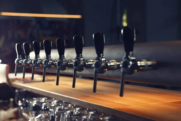 Row of shiny beer taps in pub — Stock Photo, Image