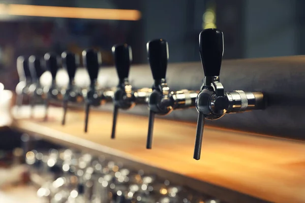 Row of shiny beer taps in pub — Stock Photo, Image