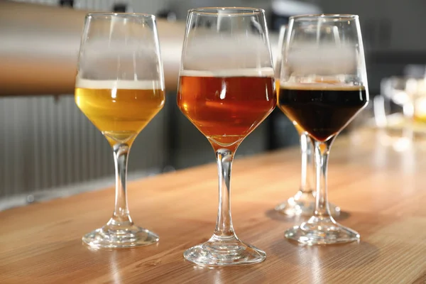 Различные сорта пива на деревянной барной стойке — стоковое фото