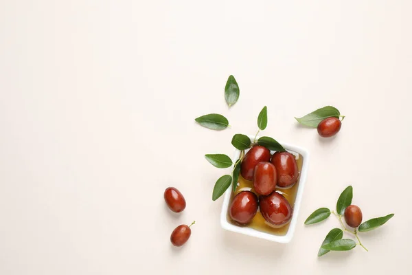 Sauce boat with jojoba oil and seeds on light background, flat lay. Space for text — Stock Photo, Image