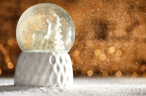 Globo de neve com veados e árvores na mesa de madeira contra luzes festivas, espaço para texto. Temporada de Natal — Fotografia de Stock