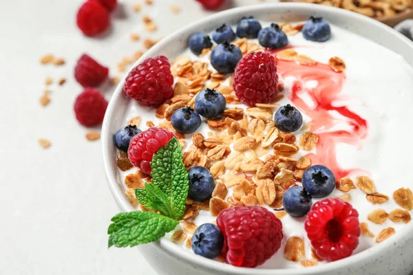 Smaklig hemlagad granola med yoghurt och bär på ljust bord, närbild. Sund frukost — Stockfoto