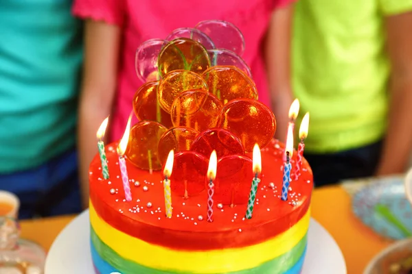 Los niños cerca de pastel con velas en la fiesta de cumpleaños en el interior, primer plano — Foto de Stock