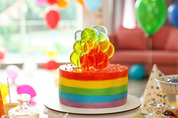 Bright birthday cake on table in decorated room — Stock Photo, Image