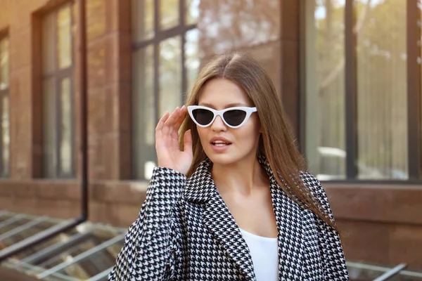 Jeune femme portant des lunettes de soleil élégantes sur la rue de ville — Photo