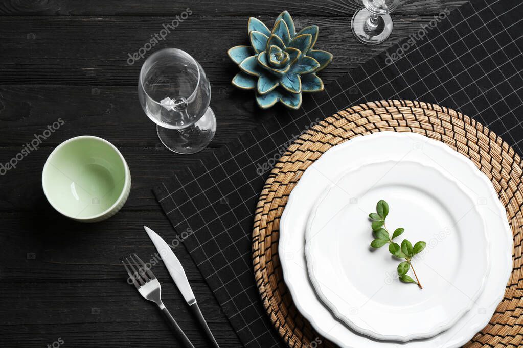 Elegant table setting on black wooden background, flat lay