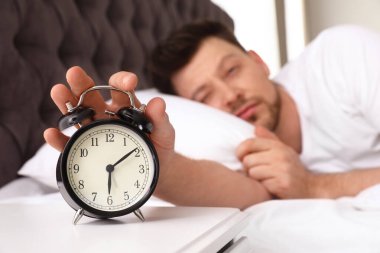 Uykulu adam komanditede çalar saati kapatıyor. Yat -madan