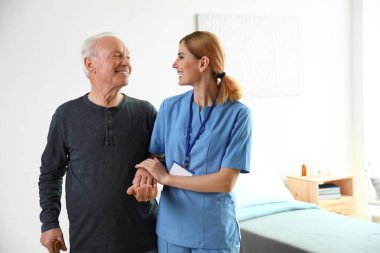 Üniformalı hemşire kapalı yaşlı kadın yardımcı