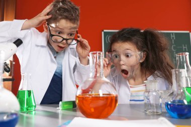 Laboratuvarda kimyasal araştırma yapan çocuklar. Tehlikeli bir deney.