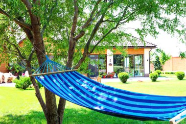 Güneşli bir günde açık havada rahat bir mavi hamak.