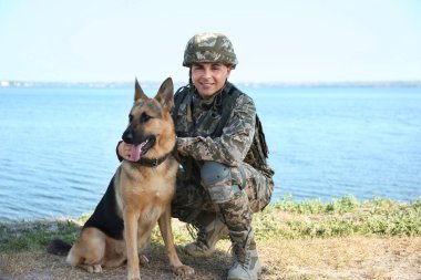 Alman çoban köpeği Nehri yakınında ile askeri üniformalı erkeklere