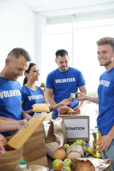 Team of volunteers collecting food donations indoors