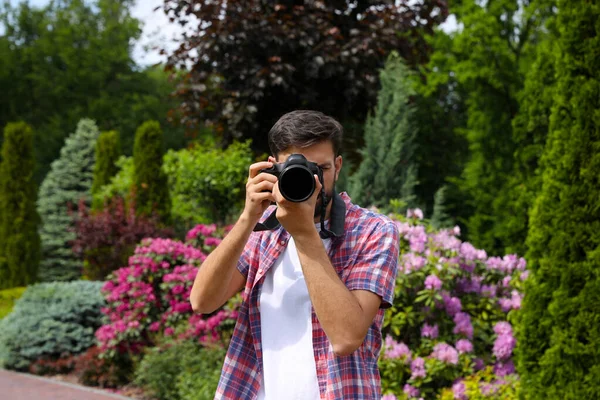 Fotograaf fotograferen met professionele camera in park — Stockfoto