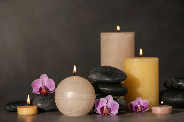 Komposition mit Kerzen und Wellness-Steinen auf grauem Tisch — Stockfoto
