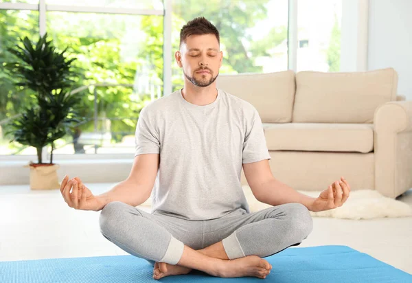 Hombre guapo practicando yoga zen en casa — Foto de Stock