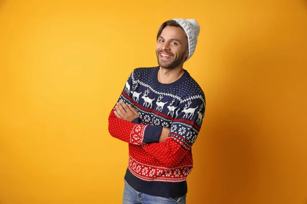 노란색 배경에 크리스마스 스웨터와 모자에 젊은 남자 — 스톡 사진