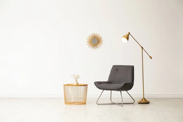 Snygg vardagsrums inredning med skön stol och sidobord nära vita muren. Utrymme för text — Stockfoto