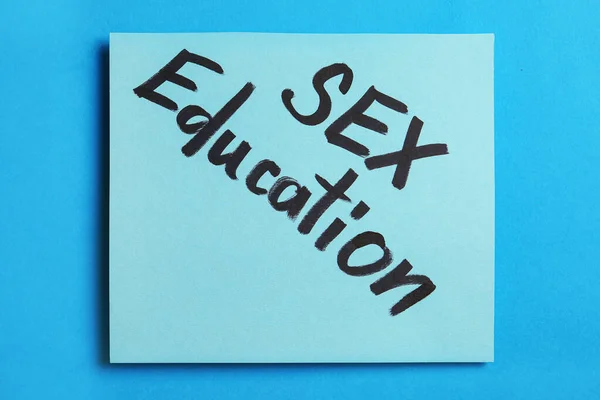 Nota com a frase "SEX EDUCATION" no fundo azul, vista superior — Fotografia de Stock