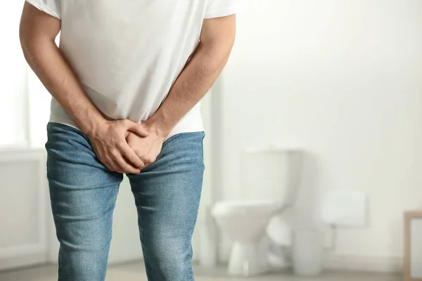 Homem sofrendo de dor dentro de casa, espaço para texto. Problemas de urologia — Fotografia de Stock