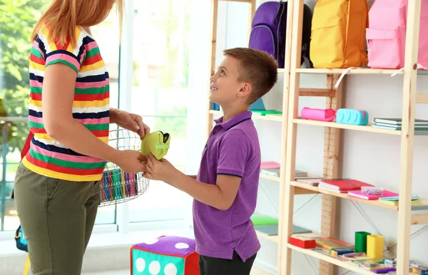 Petit garçon avec sa mère choisissant la papeterie scolaire dans le magasin — Photo