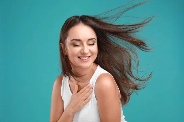 Mujer joven emocional en traje casual sobre fondo turquesa — Foto de Stock