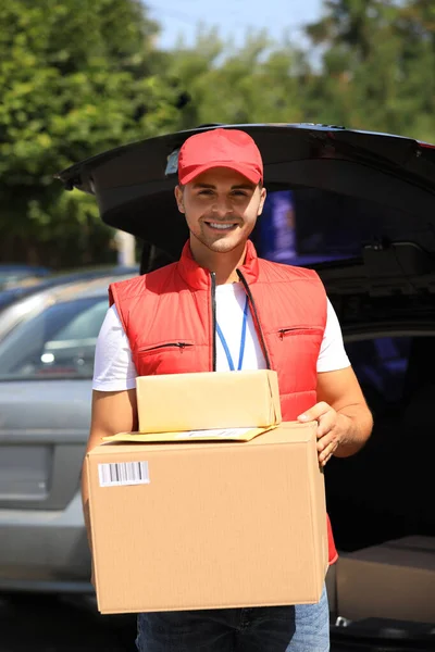 Jonge koeriers houden percelen in de buurt van levering auto buiten — Stockfoto