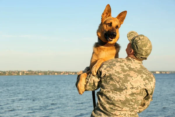 Muž ve vojenské uniformě s venku psa, německého ovčáka — Stock fotografie