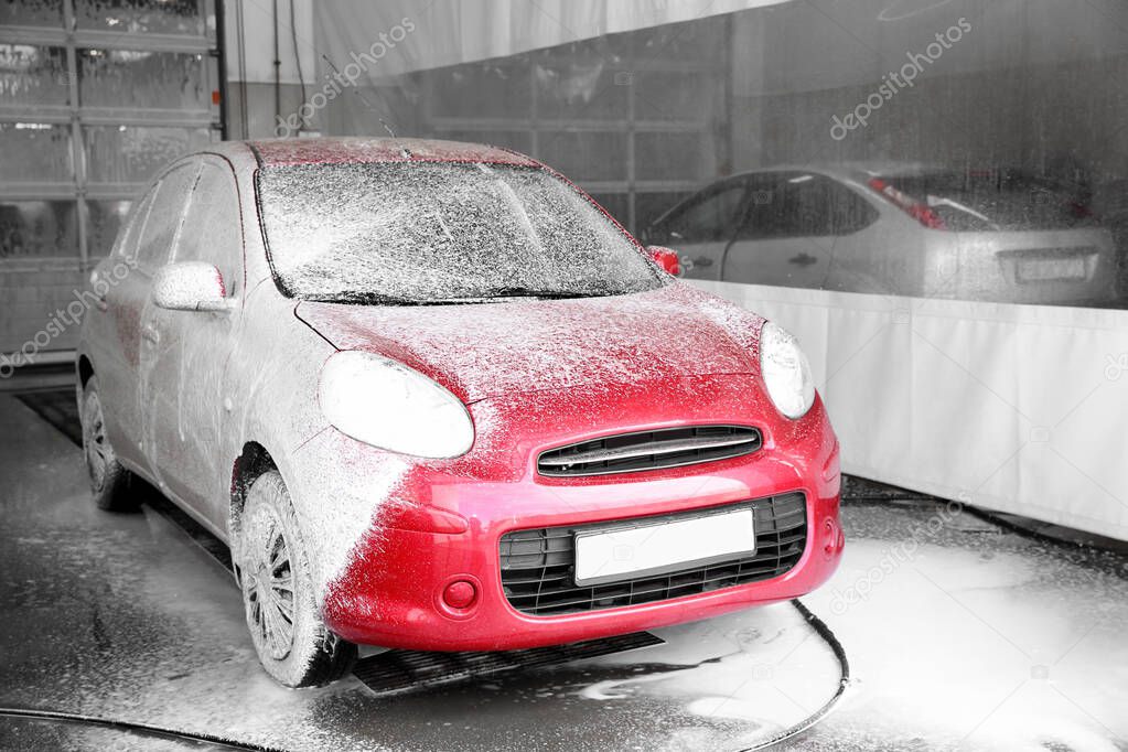 Auto covered with foam at car wash. Cleaning service