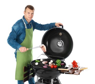 Man önlük barbekü ızgara, beyaz arka plan üzerinde pişirme