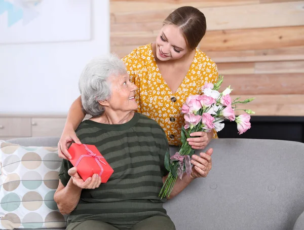 Young woman congratulating her senior mom at home. Happy Mother's Day — Stock Photo, Image