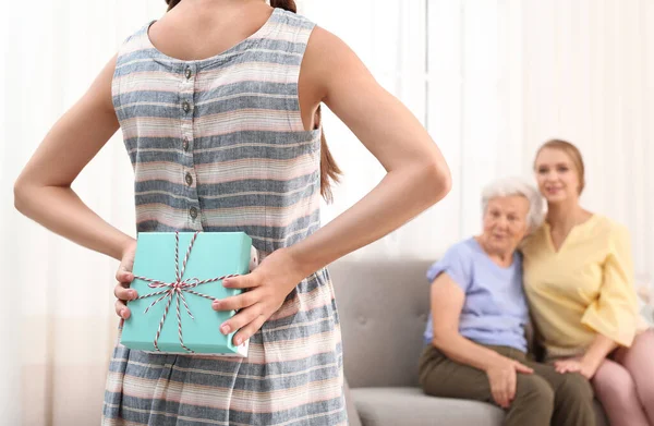 Menina felicitando sua mãe e avó na sala de estar, close-up — Fotografia de Stock