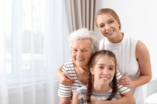 Happy sisters and their grandmother at home — Stock Photo, Image