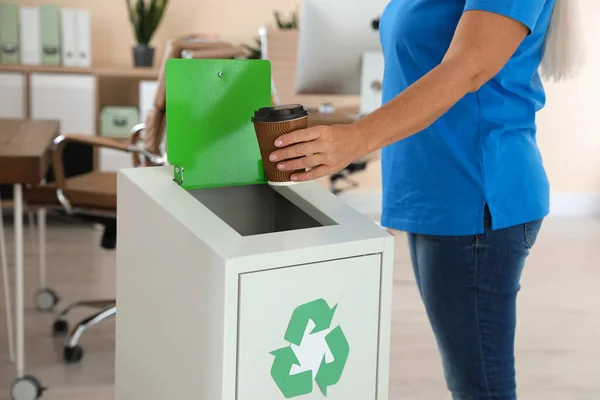 Woman throwing coffee cup into recycling bin at office, closeup — Stock Photo, Image