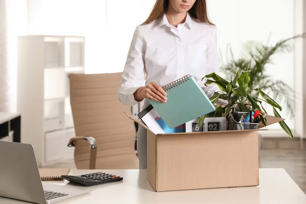 Upset young woman packing stuff in box at office — Stock Photo, Image