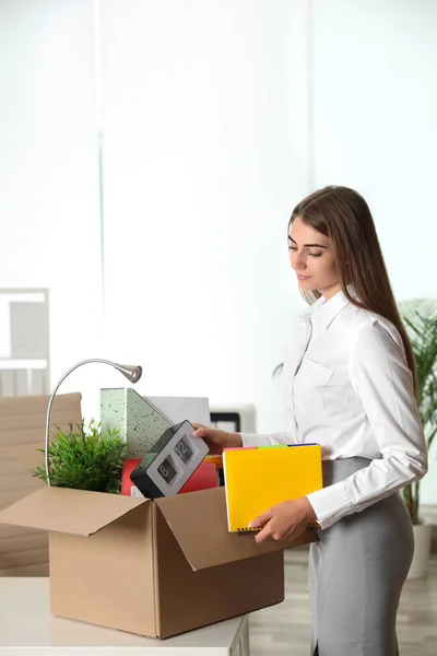 Happy young woman packing stuff in box at office — Stock Photo, Image