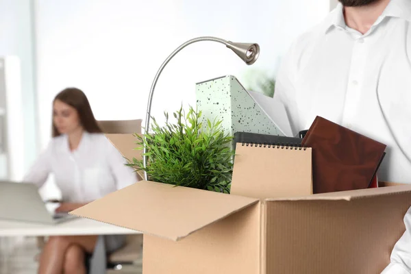 Молодий чоловік несе коробку з речами в офісі, крупним планом — стокове фото