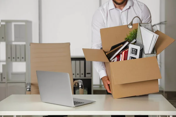 Молодий чоловік з коробкою речей в офісі, крупним планом — стокове фото