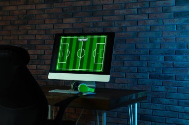 Modern bilgisayar ve kulaklıklar karanlık odada masada. Video oyunları oynanıyor