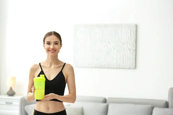 Athletic young woman with protein shake at home — Stock Photo, Image