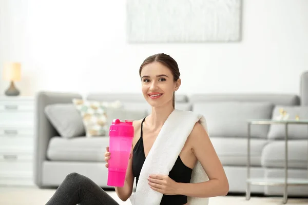 Athletische junge Frau mit Proteinshake zu Hause — Stockfoto